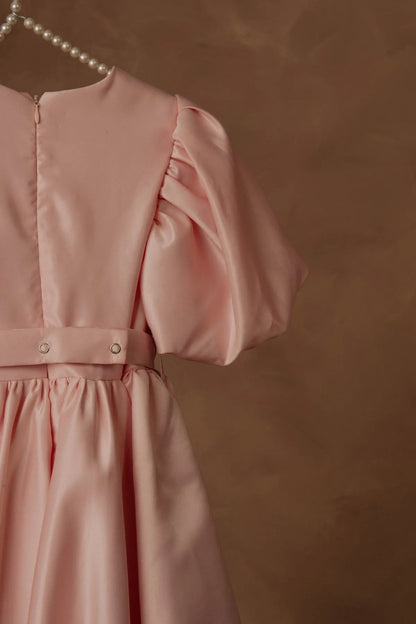 Pink puff sleeve dress bodice with button placket and gathered skirt, partial view.