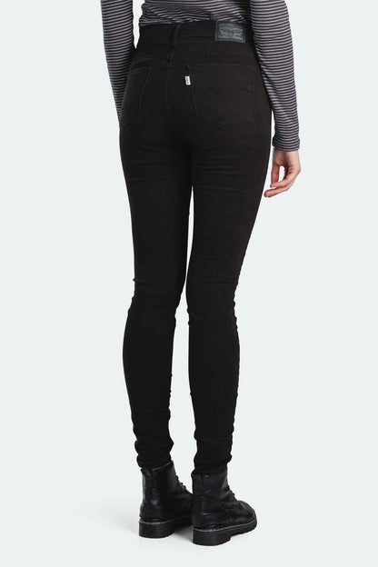 Black skinny jeans back view with small label patch on waistband.