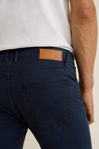 Dark navy denim jeans close-up of front pocket and tan leather logo patch