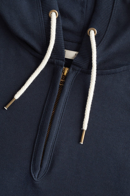 Close-up of dark navy zip hoodie front with white drawstring cords and zipper pull