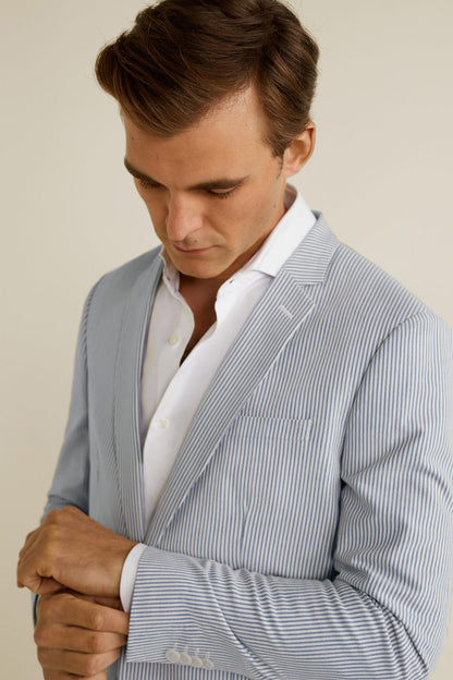 Light blue pinstripe blazer lapel and cuff detail over white shirt