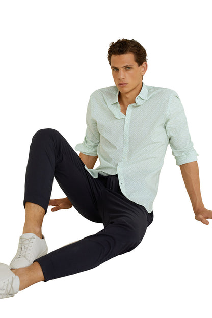 Light green patterned button-up shirt with dark trousers, long sleeves