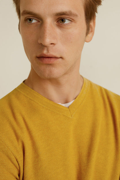 Mustard yellow V-neck knit sweater, neckline and knit fabric close-up
