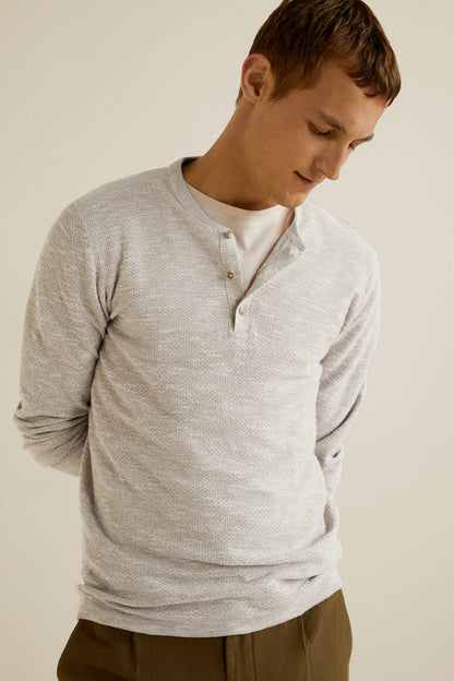 Beige long-sleeve henley shirt with button placket and ribbed cuffs