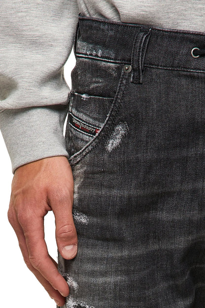 Men's black distressed jeans close-up of front pocket and drawstring waist