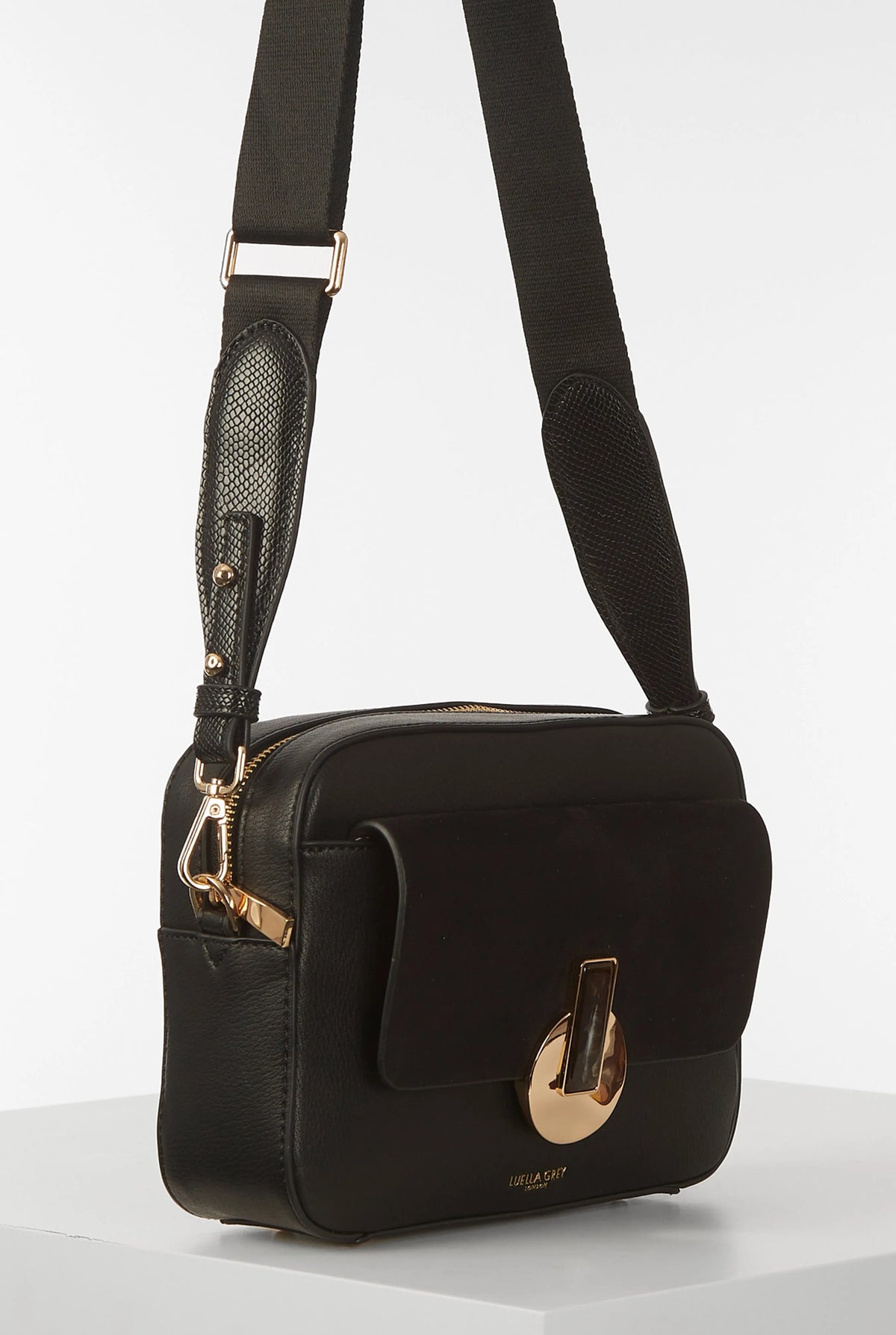 Black small shoulder bag with adjustable strap, front flap, and gold hardware