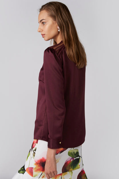 Burgundy long-sleeve blouse with floral skirt, side view