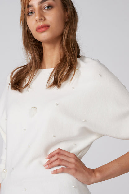 White crewneck top with small bead-like embellishments