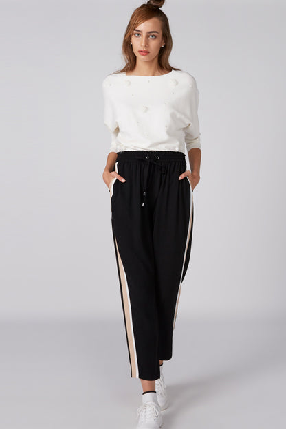 White crewneck top with three-quarter sleeves and small embellishments