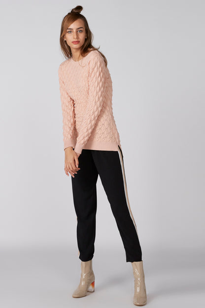 Pink cable-knit sweater with long sleeves and crew neck