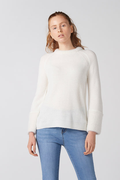 White knit crewneck sweater with long sleeves and ribbed cuffs, relaxed fit