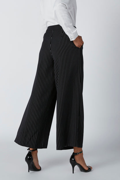 Black pinstripe wide-leg trousers, loose cropped fit and cuffed hem