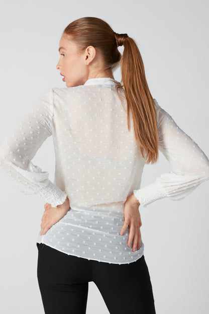 White dotted zip-front jacket back view with stand collar and ruffled hem