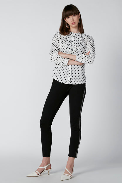 White polka-dot button-front blouse with long sleeves and rounded collar