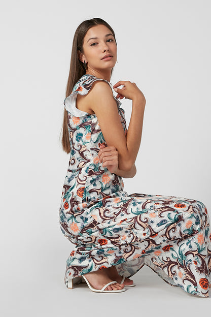 Women's sleeveless midi dress with ornate teal print and ruffled shoulders, side view.
