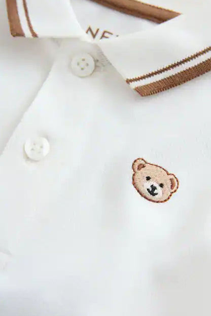 Children's white polo shirt button placket with teddy bear chest patch