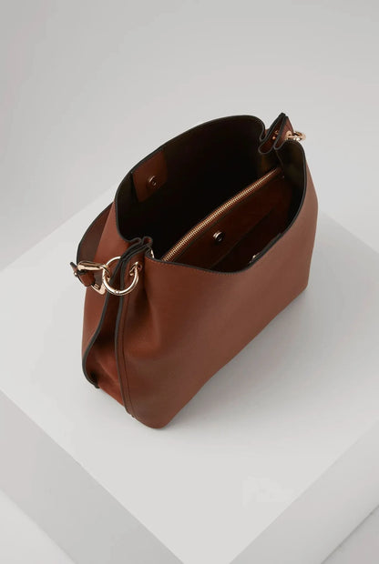 Brown leather hobo bag with adjustable strap, zipper top, and gold rings