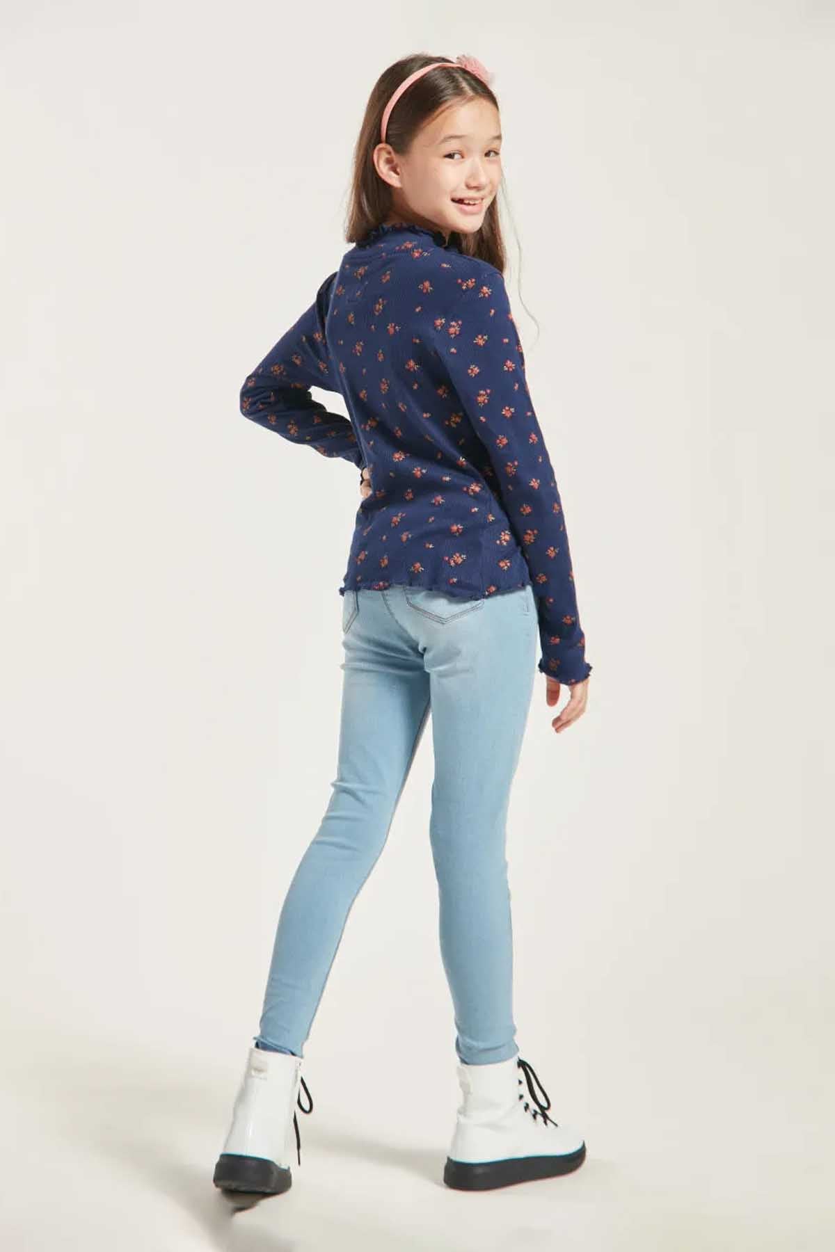 Girls navy long-sleeve patterned top with light-blue skinny jeans and boots