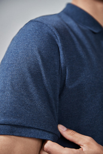 Navy polo shirt sleeve close-up with ribbed cuff and textured knit fabric