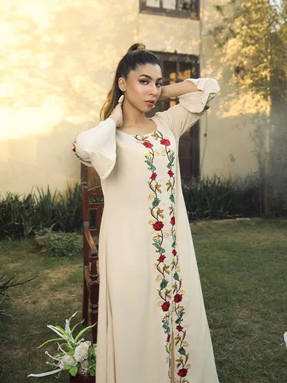 Cream midi dress with puffed sleeves and red floral embroidery, arm raised