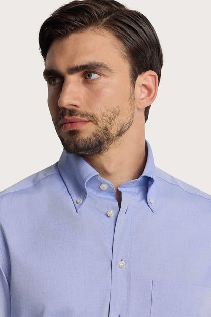 Men's light blue dress shirt collar with button placket and round white buttons
