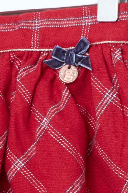 Red plaid skirt detail with navy bow and round button charm