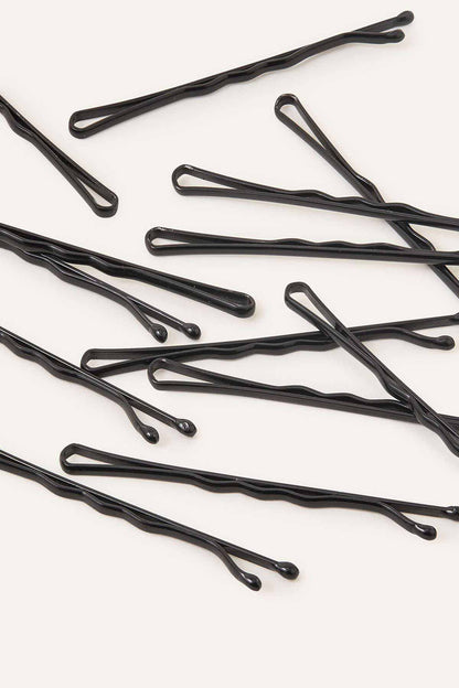 Black bobby-style hair pins, scattered on display
