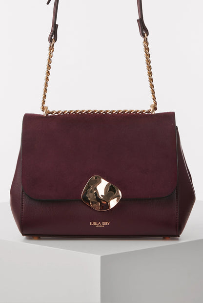 Burgundy leather flap shoulder bag with gold chain and metal clasp front