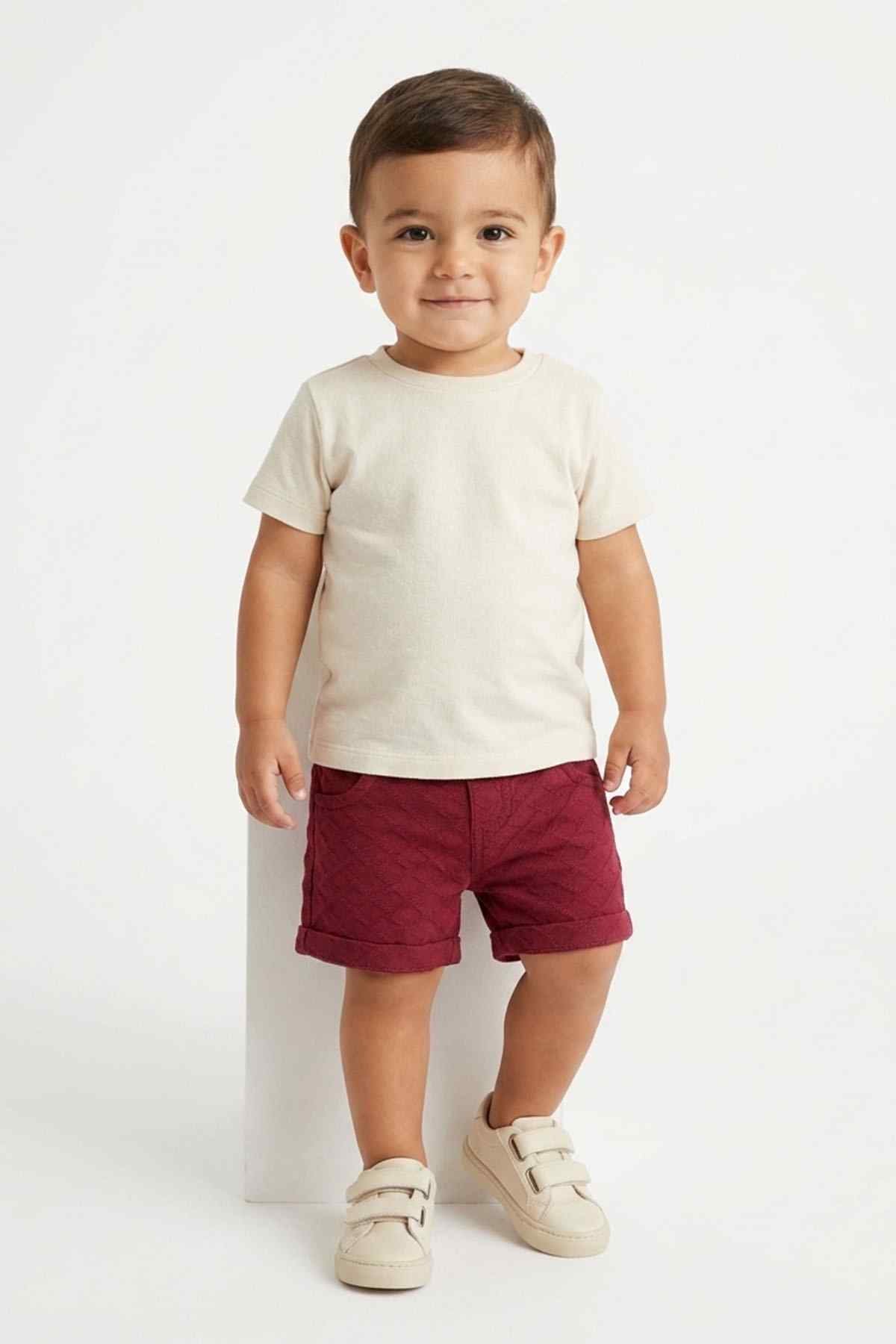 Maroon baby shorts with elastic waistband and side pockets, worn from front
