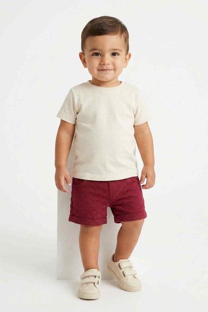 Maroon baby shorts with elastic waistband and side pockets, worn from front