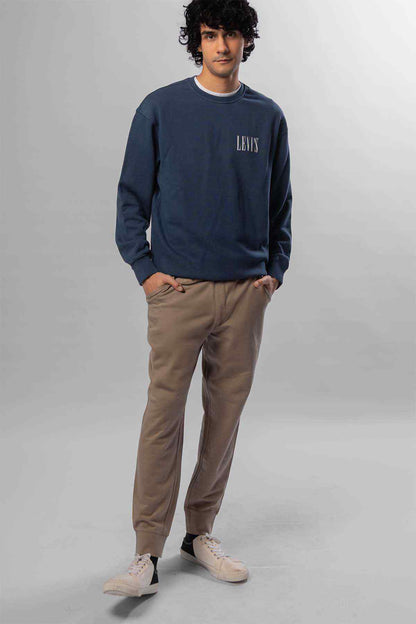 Levi's navy crewneck sweatshirt with chest logo; beige jogger pants, front view
