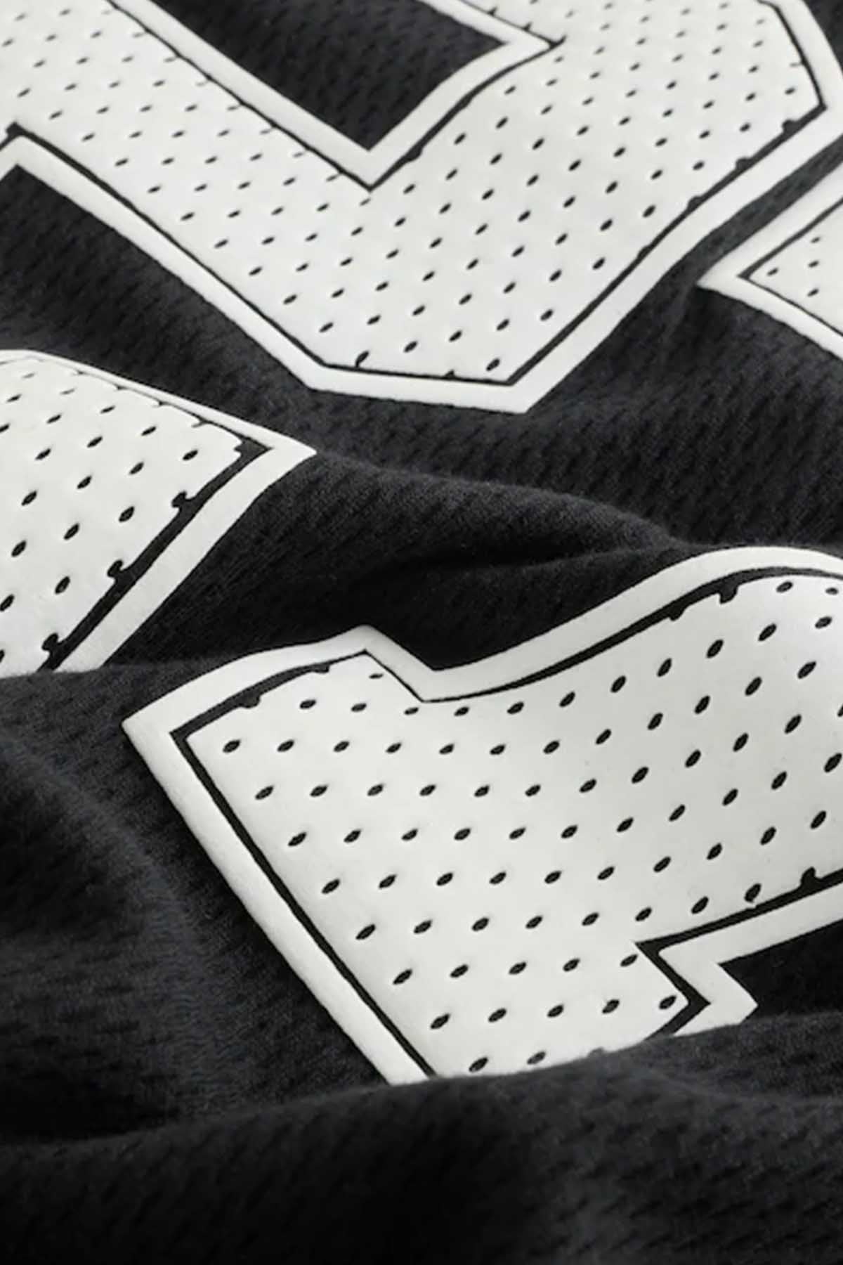 Black jersey fabric with white geometric pattern and outlined trim
