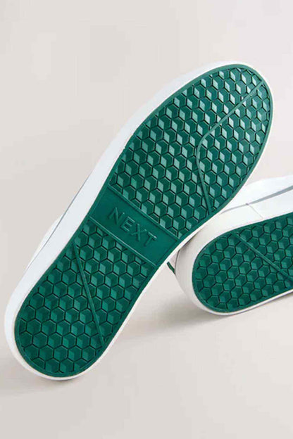 Underside of green NEXT sneakers sole with hex pattern grip