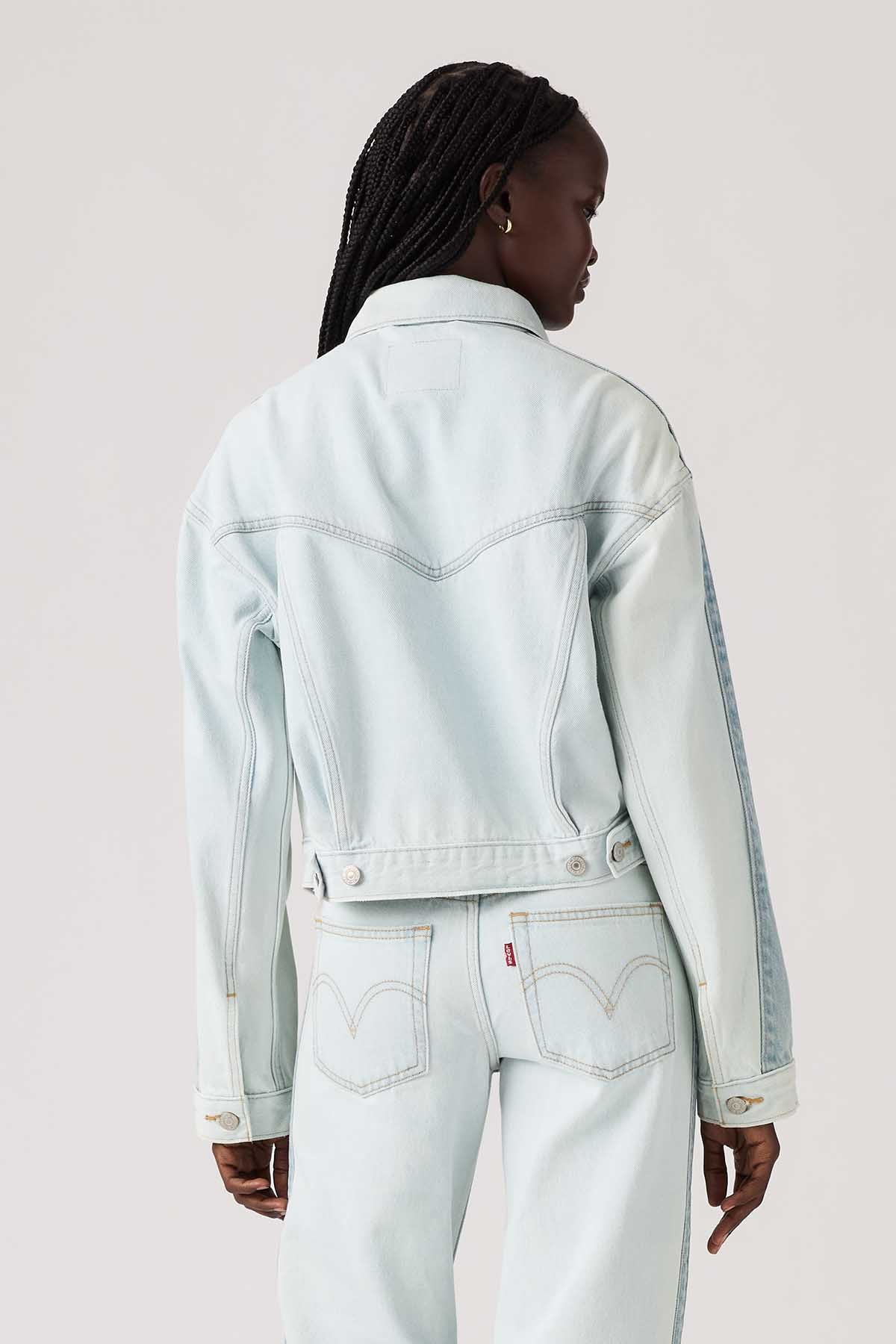 Light blue denim jacket back view with yoke stitching and buttoned cuff details