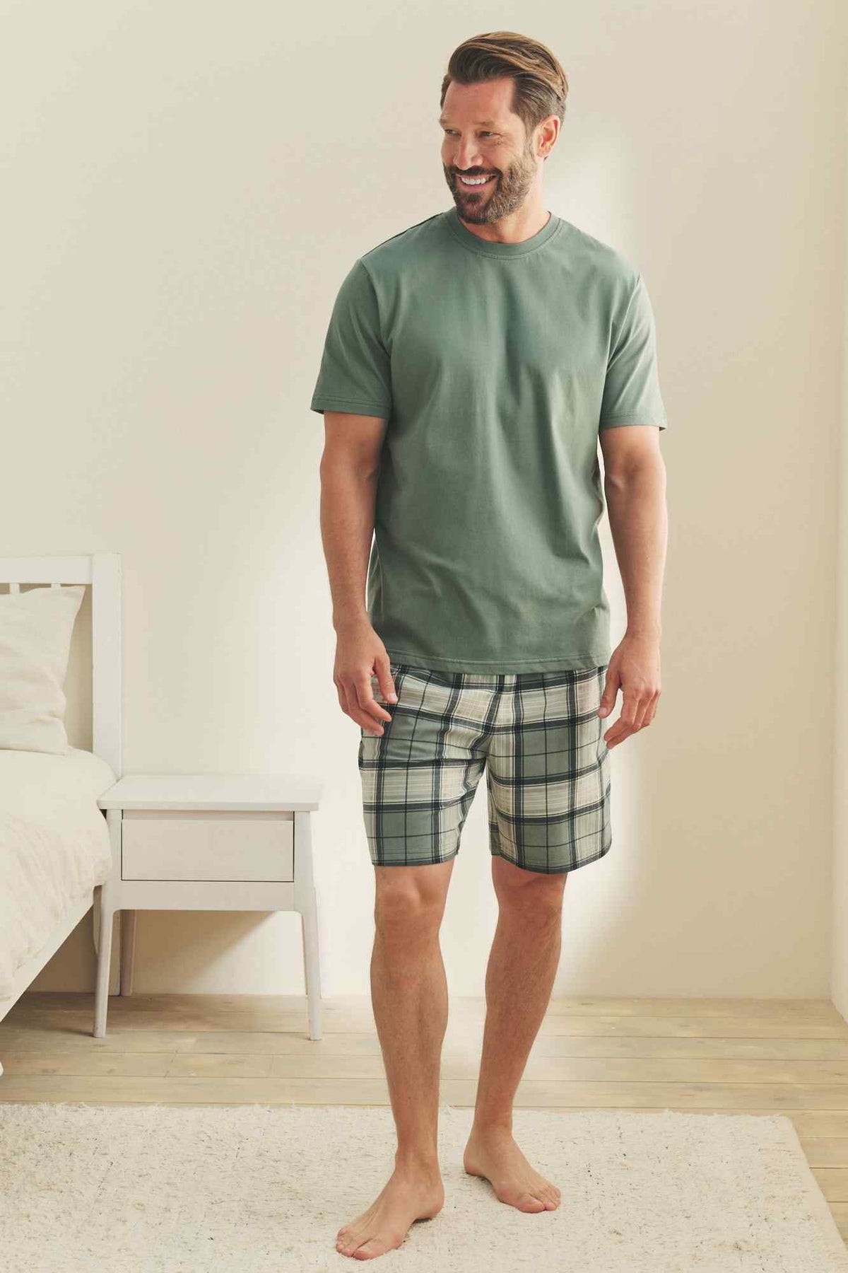 Men's green crewneck T-shirt with plaid drawstring shorts, casual loungewear set.