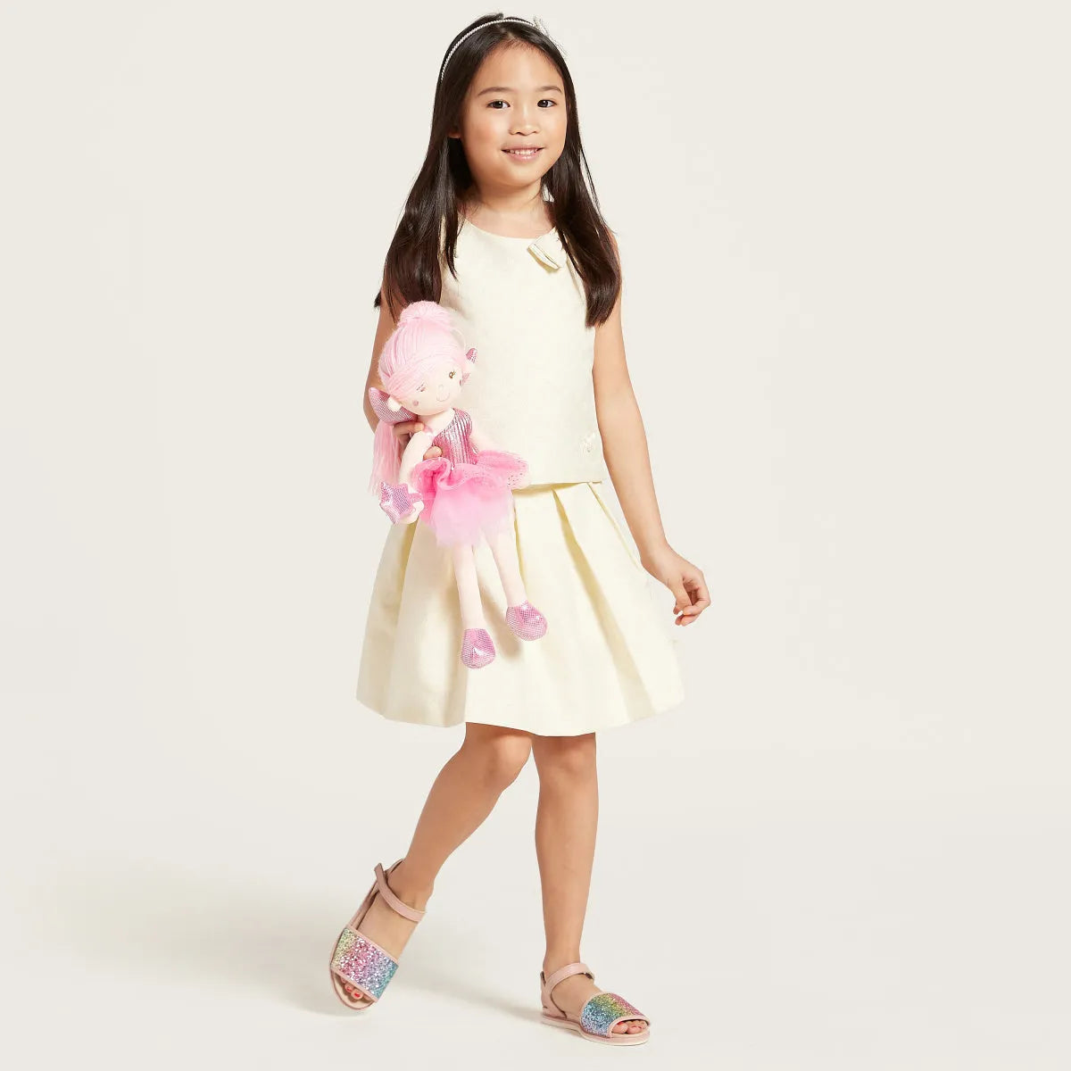 Sleeveless baby dress with cream bodice and light yellow pleated skirt