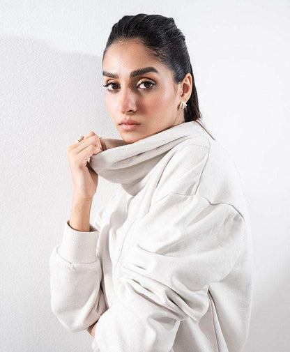 Fitted off-white hoodie with hood, long sleeves, and small chest logo