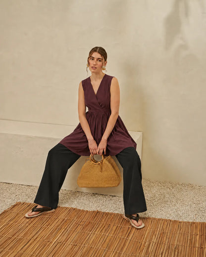 Maroon sleeveless V-neck peplum top with gathered waist and wide flared hem