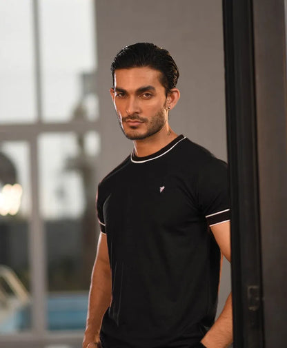 Men's fitted black t-shirt close-up with white-trim crew neck and chest logo