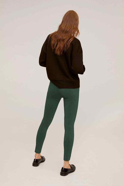 Mango black hoodie with hood and green slim pants, side/back view