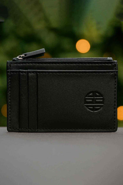 Black leather card holder with embossed emblem and zip-top closure