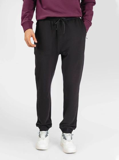 Black jogger pants with drawstring waist and relaxed tapered legs.