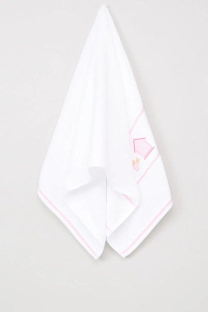 Folded white baby blanket with pink trim and small embroidered house-and-bunny design