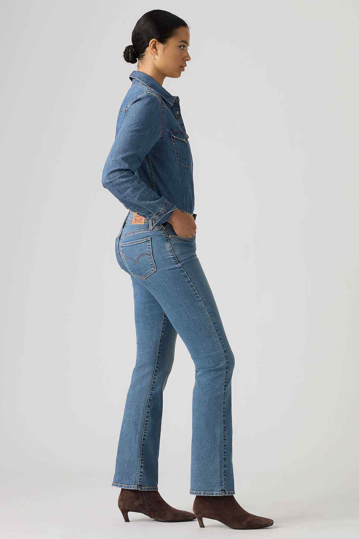 Women's medium-wash denim jeans with bootcut silhouette, stitched pockets, and belt loops