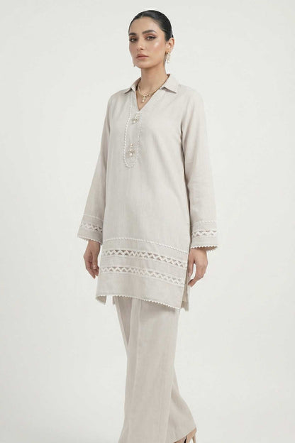 Light grey tunic with embroidered placket and lace trim, paired with trousers.