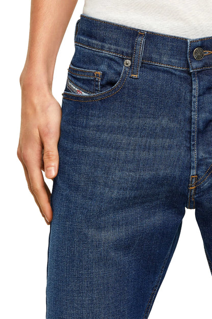 Blue denim jeans close-up: stitched front pocket and button at fly