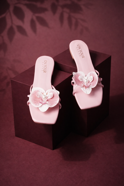 Light pink slide sandals with floral toe strap, pearl and lace-texture flower details