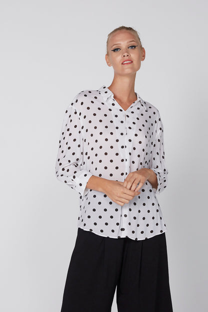 White polka-dot button-up shirt with collar and long sleeves, front view