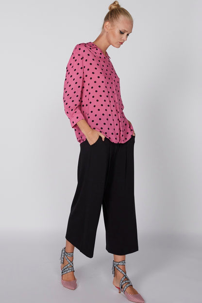 Pink polka-dot blouse with buttoned collar and long sleeves
