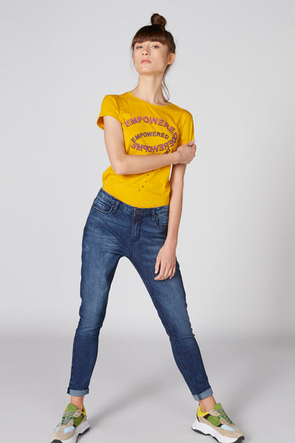 Yellow crew-neck graphic T-shirt with short sleeves, worn with blue jeans